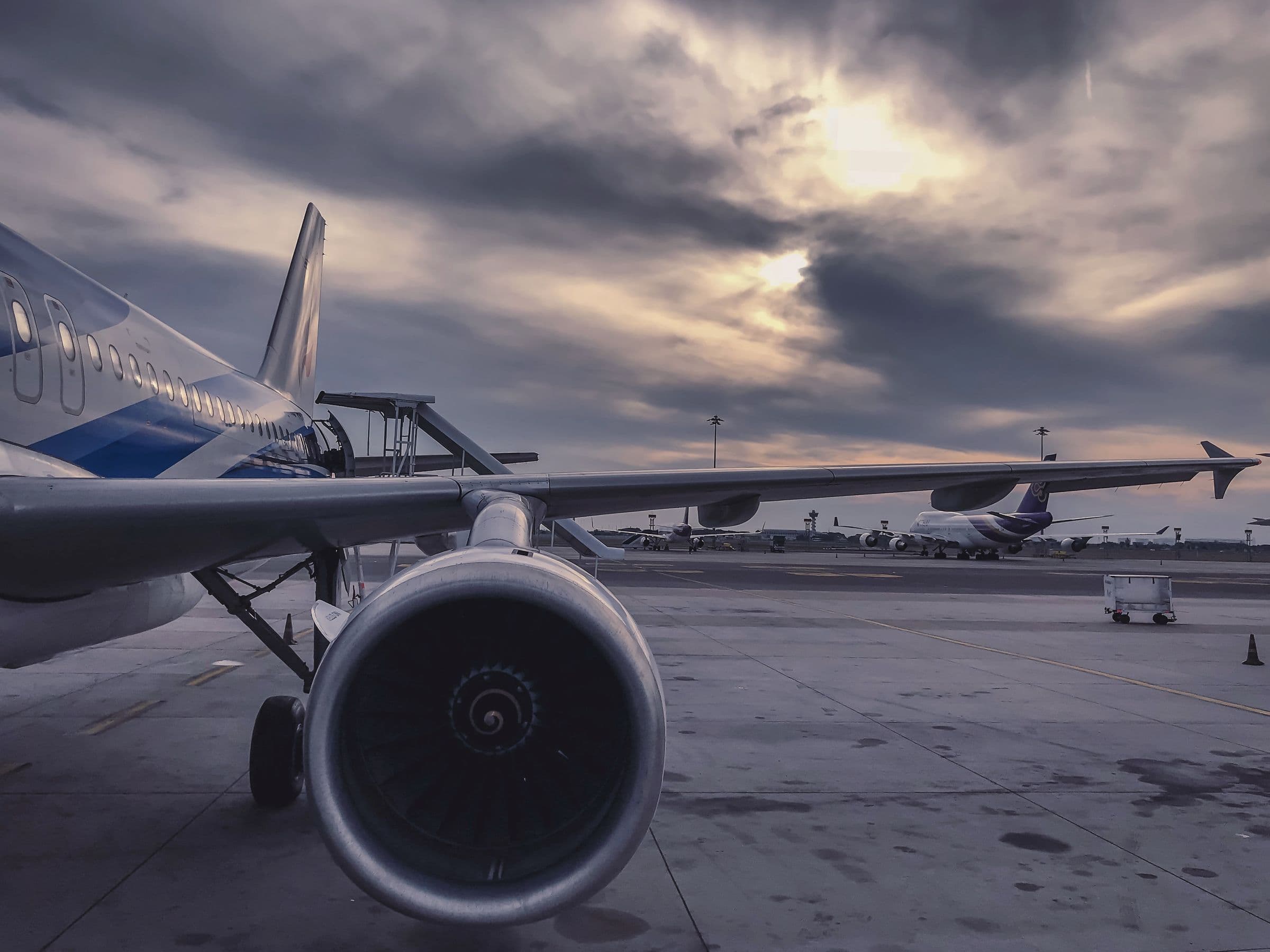 Airplane wing above clouds at golden hour